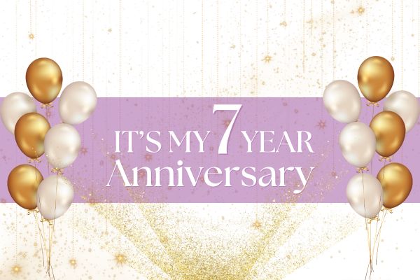 Gold and white balloons frame a pink banner that reads “It’s my 7 year anniversary” on a glittery gold background.