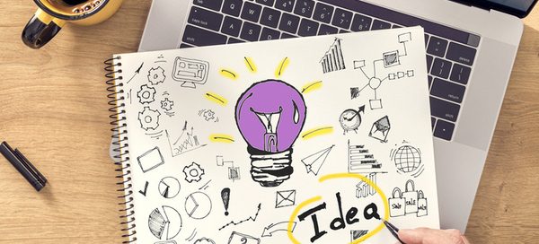 Notebook with lightbulb idea sketch showing thought leadership and white paper planning for small business content