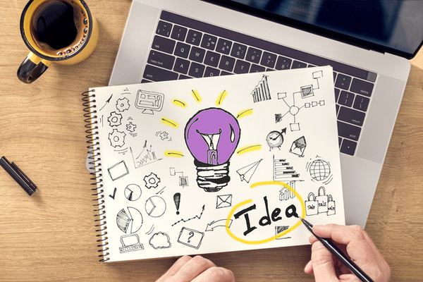 Notebook with lightbulb idea sketch showing thought leadership and white paper planning for small business content